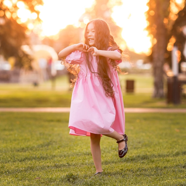 Front view asian little girl with long hair walking in the park