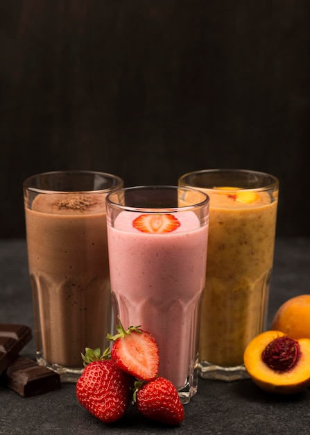 Front view of assortment of milkshakes with chocolate and fruits