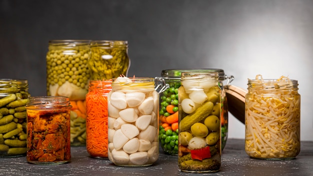 Free photo front view of assortment of vegetables pickled in clear glass jars