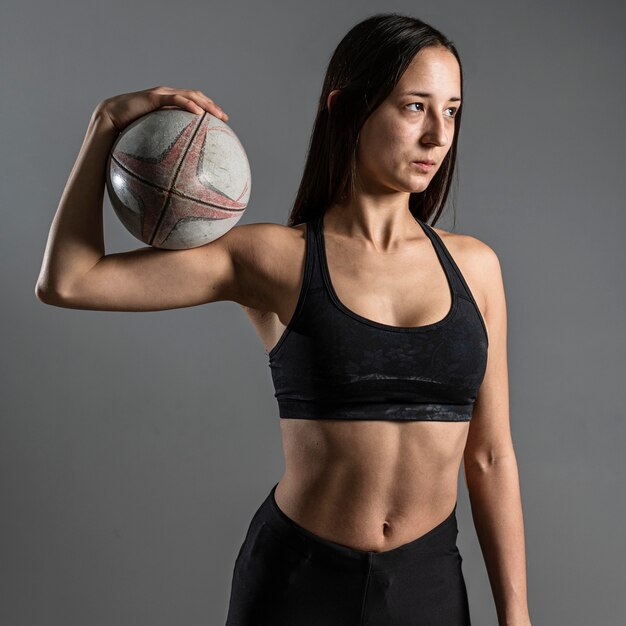 Front view of athletic female rugby player holding ball