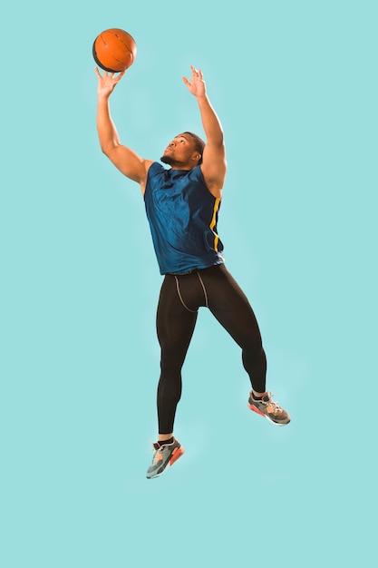 Free photo front view of athletic man in gym wear playing basketball