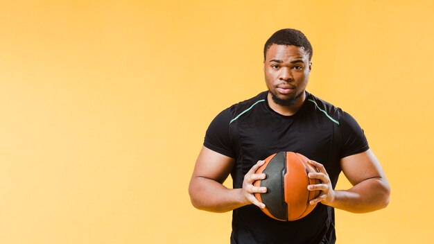 Front view of athletic man holding basketball