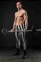 Foto gratuita vista frontale dell'uomo atletico che tiene insieme del peso