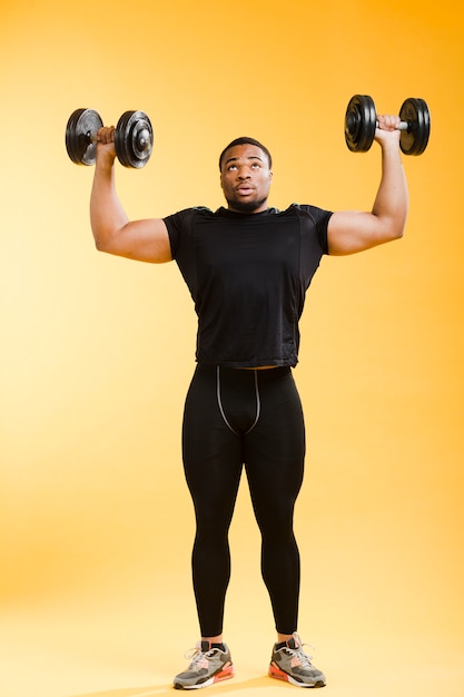 Front view of athletic man holding weights