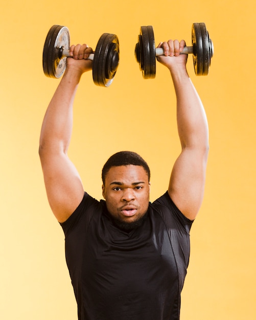 Free photo front view of athletic man lifting weights