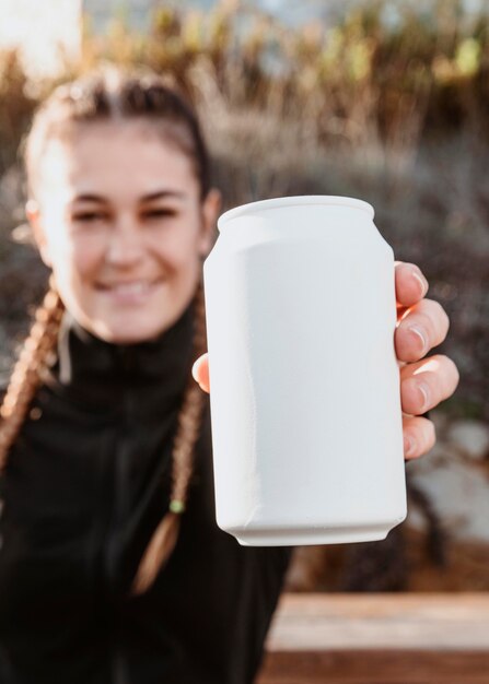 Front view of athletic woman showing soda can