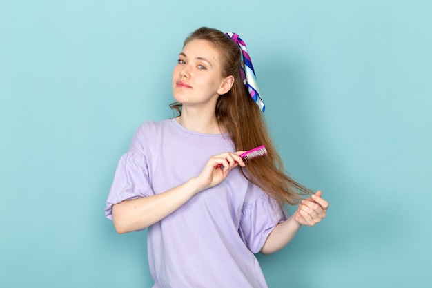 Free photo a front view attractive female in blue shirt-dress fixing her hair on blue