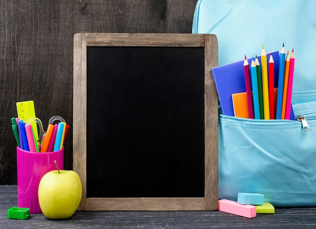 Front view of back to school stationery with colorful pencils and blackboard