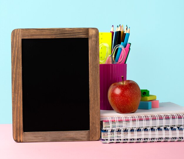 Front view of back to school supplies with blackboard and pencils