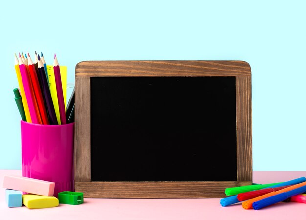 Front view of back to school supplies with blackboard and pencils