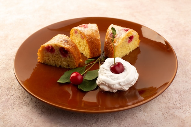 Вид спереди запеченный фруктовый торт, восхитительный, нарезанный красной вишней внутри и сахарной пудрой внутри круглой коричневой тарелки на розовом