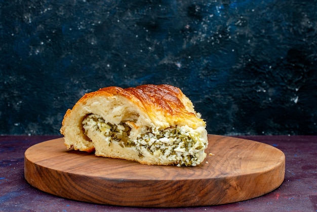 Front view baked pastry bun formed sliced with greens inside on the dark background.