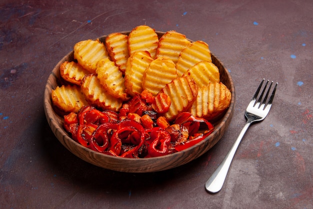 Вид спереди запеченный картофель с вареными овощами внутри тарелки на темном пространстве