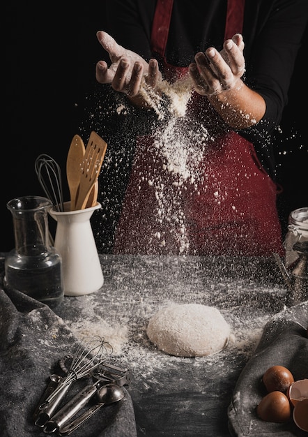 Free photo front view baker hands spreading flour