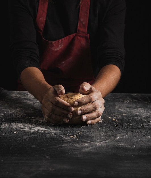 Free photo front view baker kneading dough