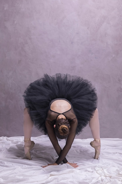 Free photo front view ballerina bending over in ballet shoes