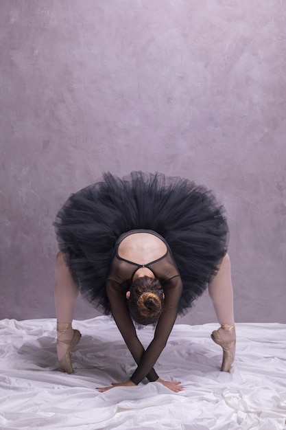 Бесплатное фото Вид спереди балерина склоняется в балетных туфлях