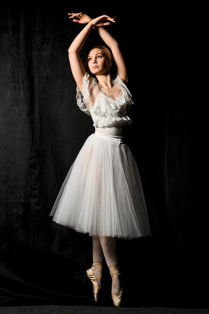 Front view of ballerina posing in pointe shoes and tutu dress