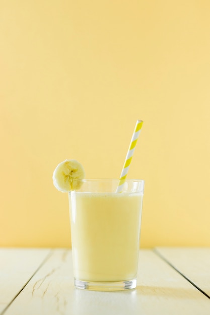 Вид спереди банановый молочный коктейль с соломой
