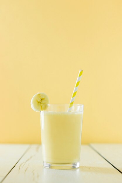 Front view of banana milkshake with straw