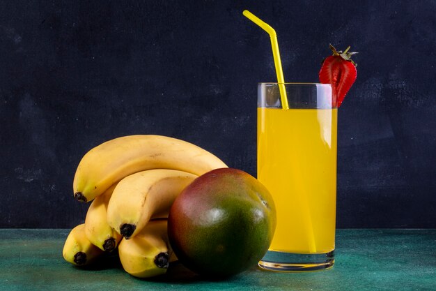 Front view bananas with mango and a glass of orange juice