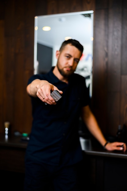 Free photo front view of barber holding blade clipper