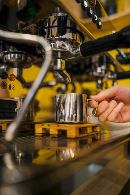 Foto gratuita vista frontale della mano barista alla macchina per il caffè