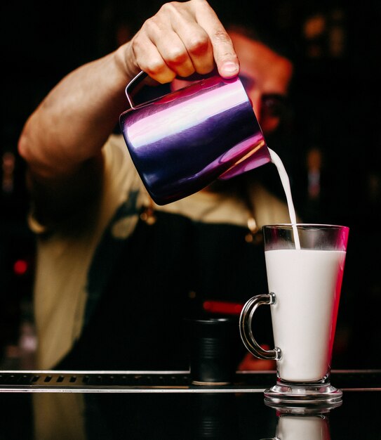 Front view bartender filling glass with juice