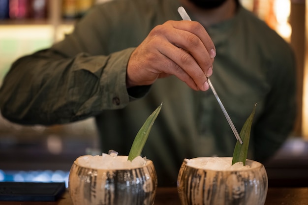 Free photo front view bartender making pina colada