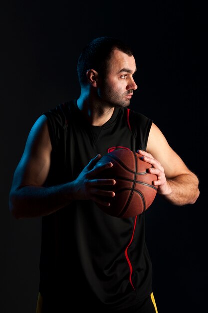 Front view of basketball player posing with ball