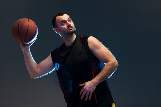 Вид спереди баскетболиста, бросающего мяч