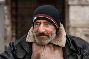 Free photo front view of bearded homeless man outdoors