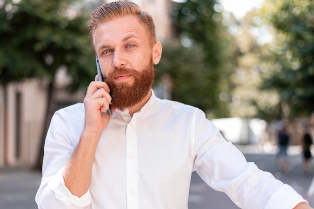 Front view bearded modern man talking on the phone