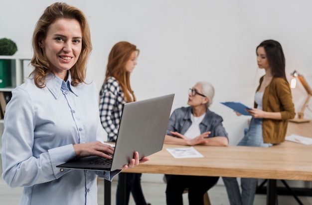 Front view beautiful adult woman holding a laptop