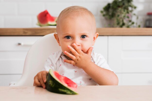 수박을 먹는 아름다운 아기의 전면보기