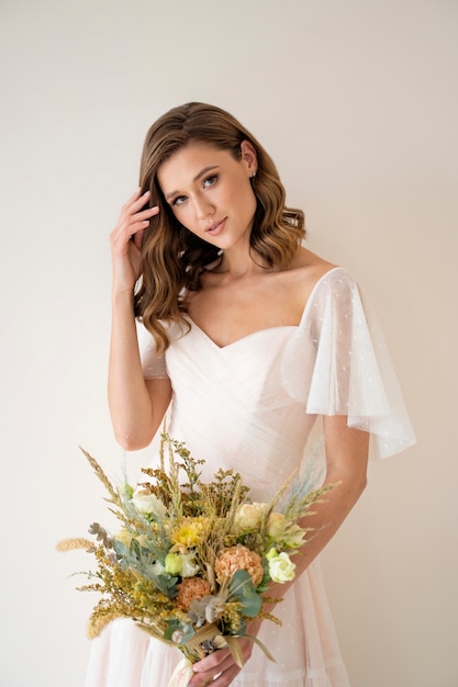 Foto gratuita fiori della holding della bella sposa di vista frontale