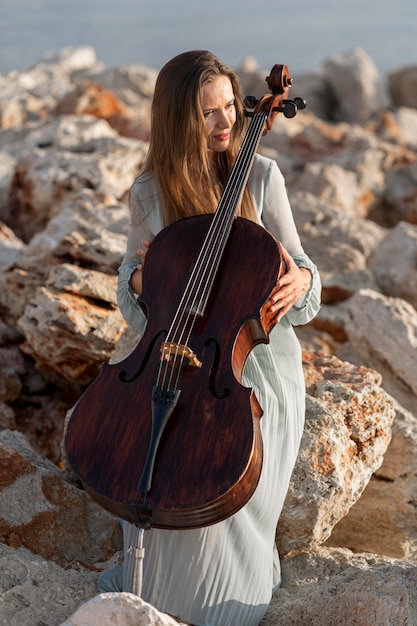 Foto gratuita vista frontale del bellissimo musicista femminile con il violoncello