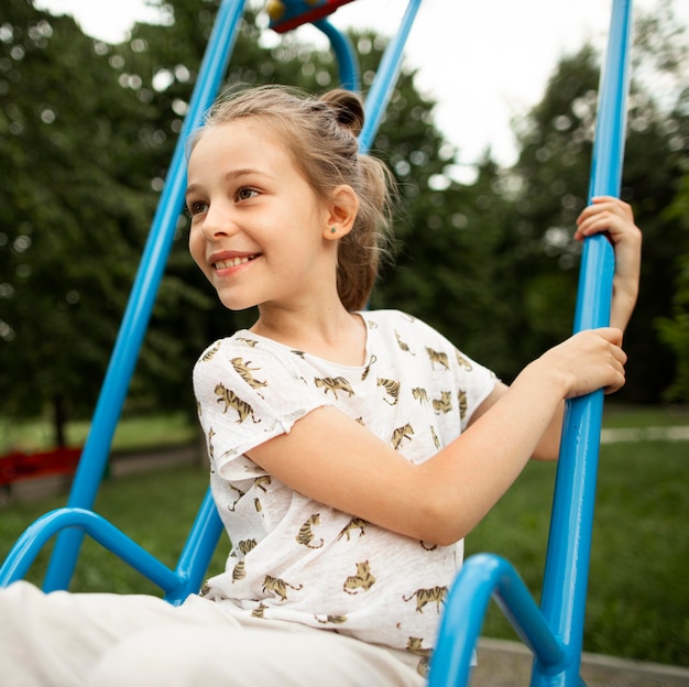 Front view of beautiful happy girl in swing