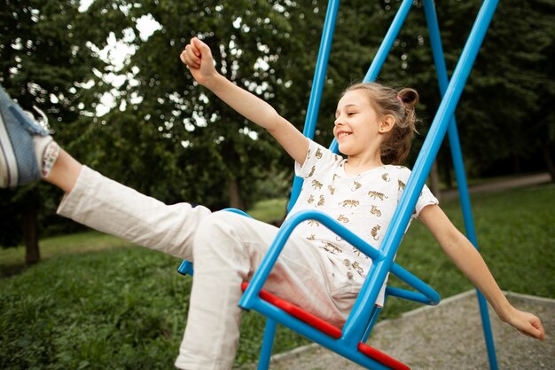 Front view of beautiful happy girl in swing