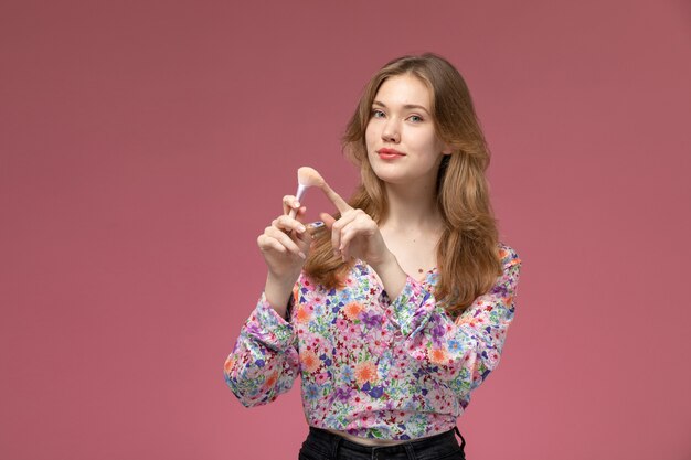 Front view beautiful lady pointing out her cosmetic powder brush