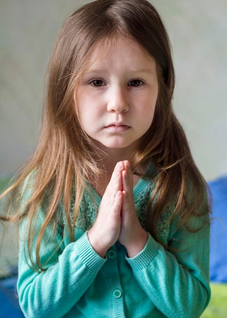 Free photo front view of beautiful little girl praying