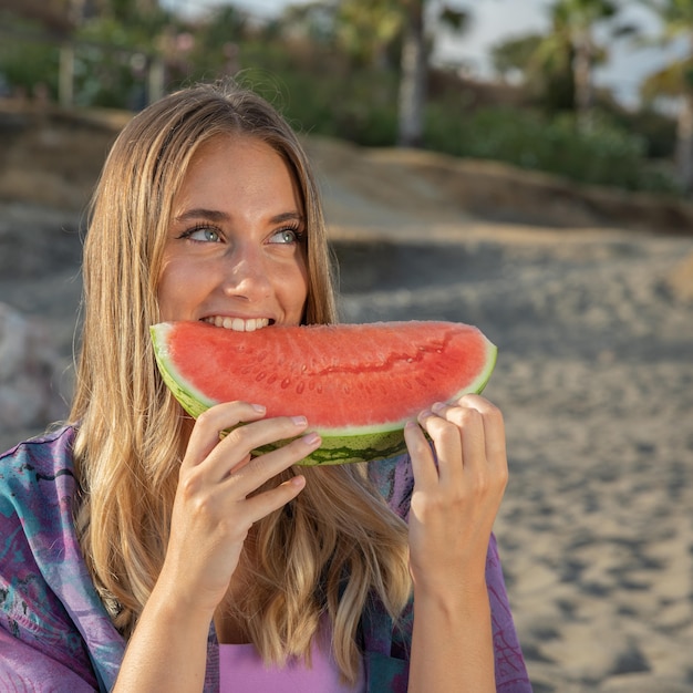 Front view of beautiful woman eating watermelon