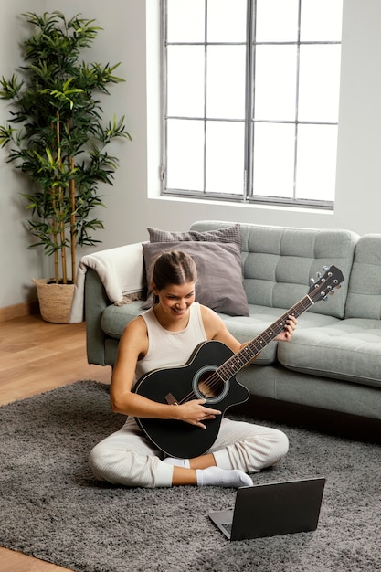Free photo front view of beautiful woman playing guitar