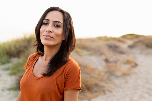 Front view of beautiful woman posing by the beach