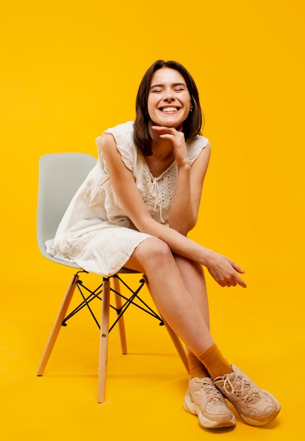 Front view of beautiful woman sitting on chair