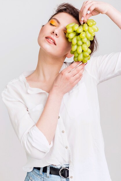 Front view of beautiful woman with grapes