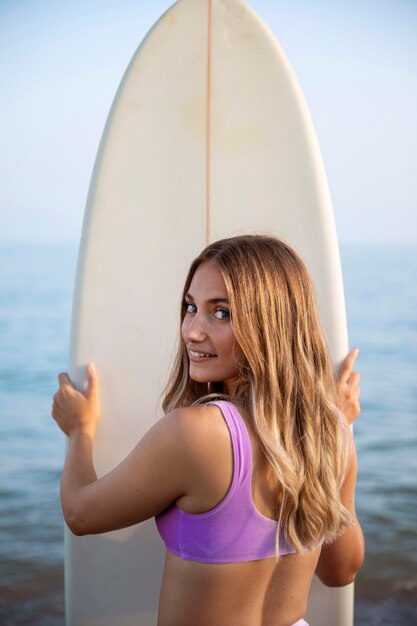 Front view of beautiful woman with a surfboard