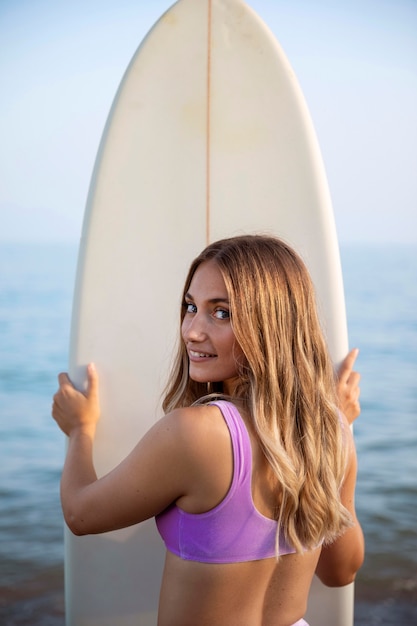 サーフボードを持つ美しい女性の正面図