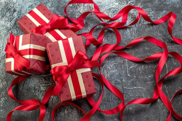 Front view of beautifully packaged gift boxes tied with ribbon on icy dark