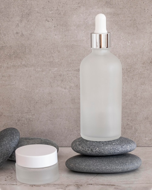 Front view beauty products in recipients on grey rocks